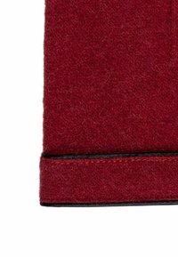 Burgundy wool fabric with a soft texture and a black leather trim at the bottom, showcasing a clean, straight edge and fine stitching.