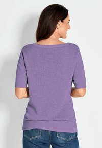 Paars T-shirt met korte mouwen in een losse fit, van gebreide stof met textuur, brede halslijn en geribbelde manchetten en zoom. Gecombineerd met denim jeans.