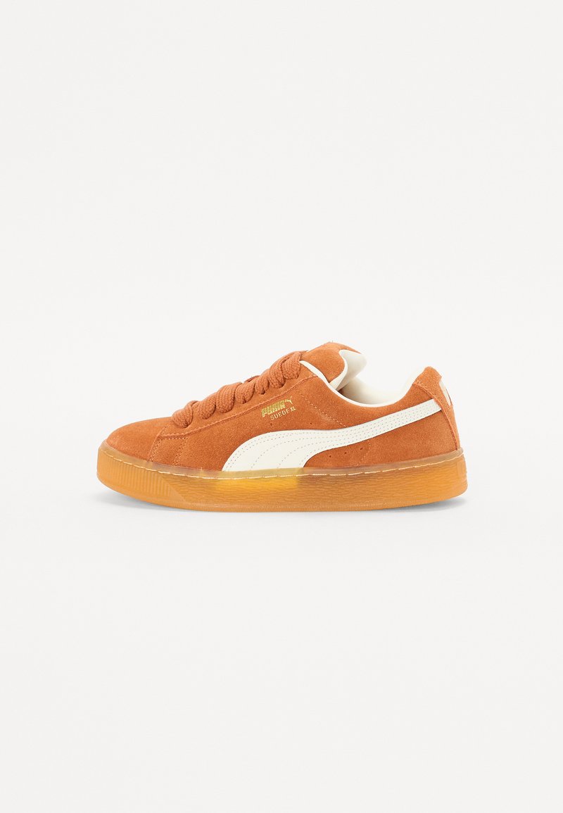 Oransje semsket sneakers med hvite detaljer, med rund tå, flate lisser og en teksturert gummiyttersåle. Gulllogo på siden.