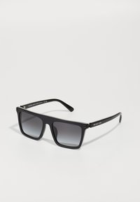 Occhiali da sole neri con lenti sfumate, montatura in acetato elegante, con leggere accentuazioni hardware, che presentano il nome del marchio "Michael Kors" sulle asticelle.