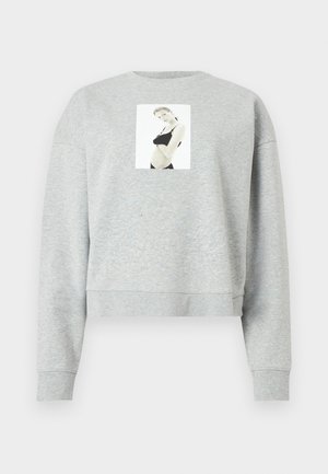 Maglione grigio corto realizzato in un tessuto morbido, con una stampa fotografica frontale centrata sul petto. Maniche e collo a costine.