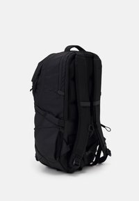 Schwarzer Rucksack mit gepolsterten Schultergurten, mehreren Reißverschlussfächern und verstellbaren Seitenschnüren. Hergestellt aus strapazierfähigem, strukturiertem Stoff.
