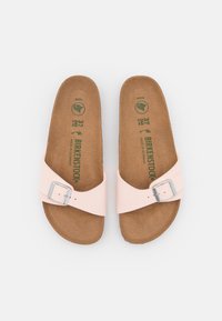 Pink vegan leather sandals with a single buckle strap and cork footbed. Features a textured insole with embossed brand logo in green.