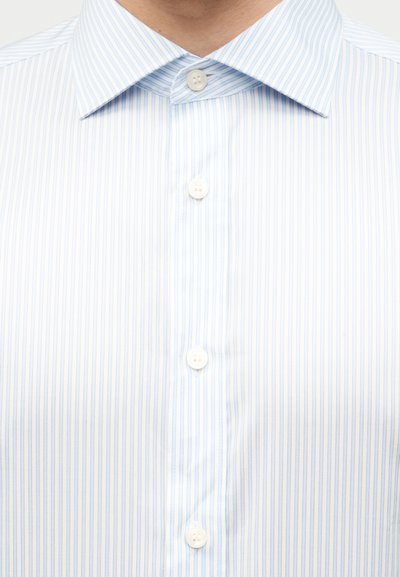 Φωτεινό μπλε και λευρό πουκάμισο με κάθετες ρίγες, λευκά κουμπιά και κλασικό μυτερό γιακά.