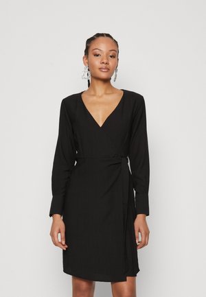 Black wrap dress with long sleeves, V-neckline, textured fabric, and a tie waist. Features a side slit and straight hem.