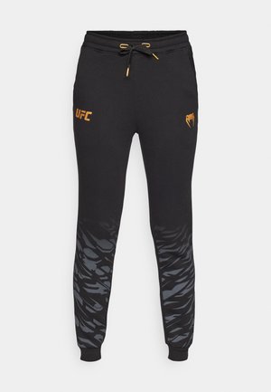 Venum UFC FUSION WOMENS REPLIICA PANT CHAMPION - Tracksuit bottoms - black/gold