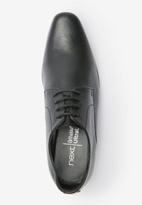 Chaussure habillée en cuir noir avec un bout arrondi, design à lacets et texture lisse. Elle est dotée d'une semelle intérieure Ortholite Ultra pour un confort optimal.