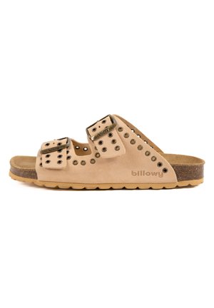Sandales en suède beige avec deux sangles ajustables, dotées d'accents en métal ronds et d'une semelle intermédiaire en liège, montées sur une semelle extérieure en caoutchouc texturé.