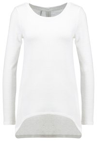 Maglietta a maniche lunghe bianca realizzata in tessuto a maglia testurizzato, con colletto rotondo e orlo leggermente curvo per una silhouette allungata.