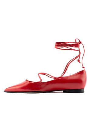 Rote lederne Ballerinas haben eine spitze Zehenpartie, einen Knöchelriemen mit Bindebändern und einen niedrigen Absatz. Glatte Oberfläche mit ausgeschnittenen Designdetails.