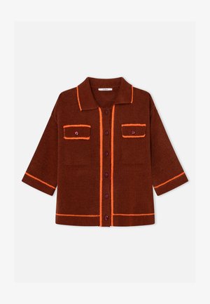 Cardigan marrone lavorato a maglia con rifiniture arancioni, collo e fronte con bottoni. Presenta due tasche sul petto e maniche corte. Tessuto testurizzato.