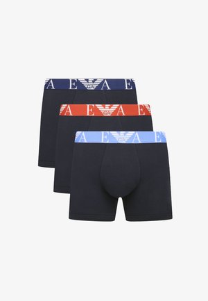 Three pairs of boxer shorts in dark navy, featuring elastic waistbands in navy, red, and light blue, with logo detailing.