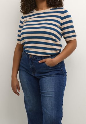 Gestreepte gebreide trui met korte mouwen in beige en blauw, gecombineerd met hoge taille donkerblauwe spijkerbroek. Zachte textuur, relaxed fit en ronde halslijn.