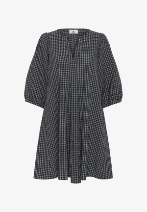 Melna baltā rūtainā kleita ar V veida izgriezumu, pūstām piedurknēm un vaļēju piegriezumu ar krokām no korsetes līdz apakšmalai.