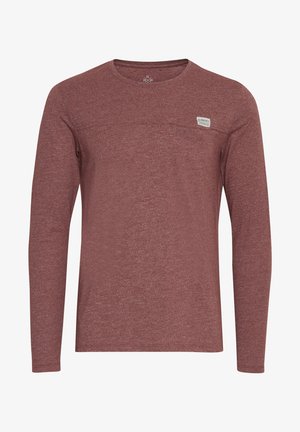 Burgundinės ilgarankovės marškiniai, pagaminti iš tekstūruotos medžiagos. Suapvalintas iškirpimas ir maža etikė ant krūtinės. Paprastas, kasdienis dizainas.