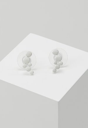 White circular earrings with textured silver accents and clear material, featuring multiple small spheres arranged asymmetrically.