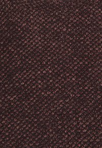 Texturerat tyg i mörk burgund med sammanflätade ljusare trådar, vilket skapar ett rikt, mångdimensionellt utseende. Mjuk och stickad konstruktion.