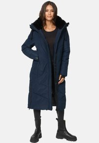 Lange marineblauwe pufferjas met zwarte faux fur voering, frontale rits en zijzakken. Voorzien van een capuchon en een gewatteerd patroon voor textuur.
