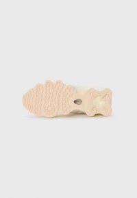Lightweight sneaker with a textured, cream rubber outsole featuring unique patterns and grooves. The upper has a soft, muted color design.