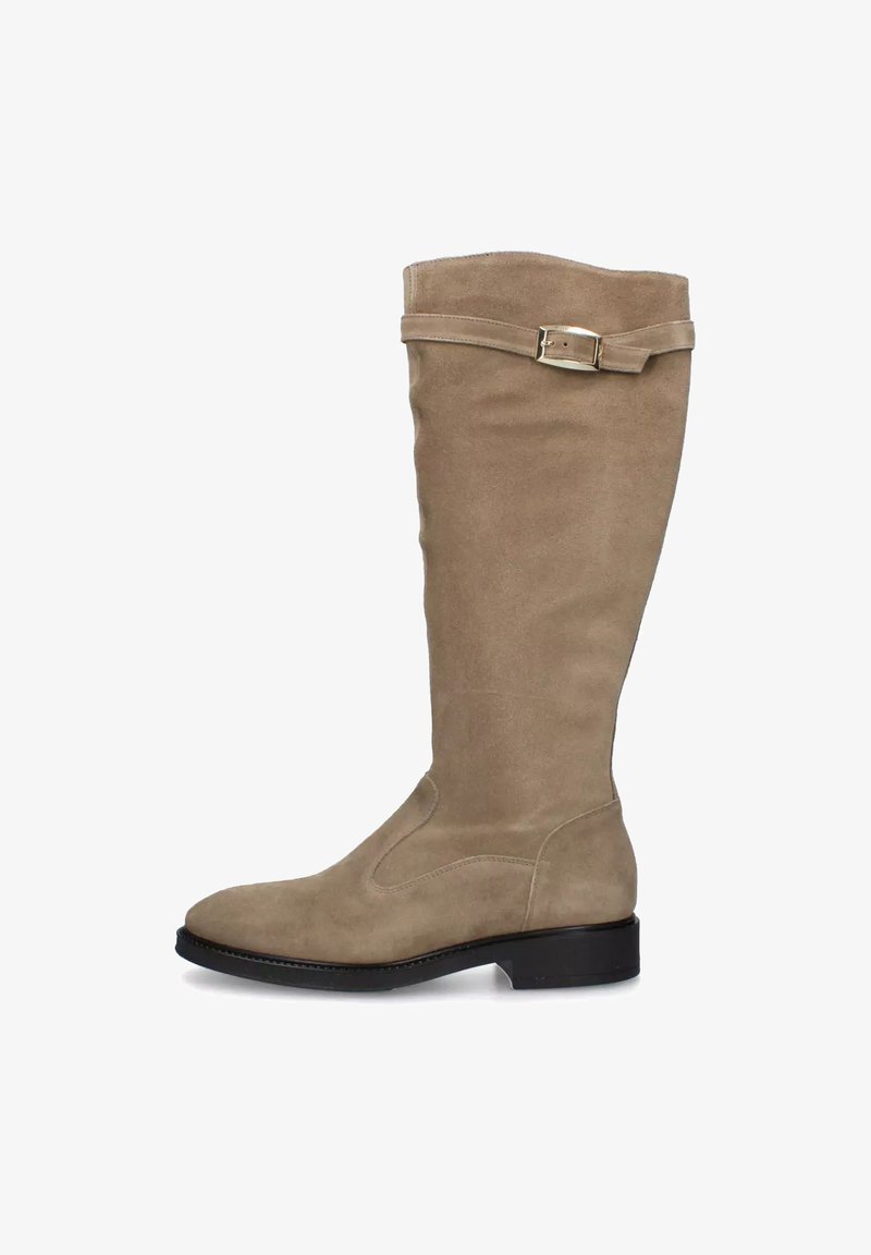 Bota alta de gamuza beige con un tacón negro bajo y una correa decorativa con hebilla dorada cerca de la parte superior.