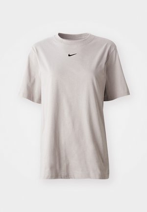 Vaaleanharmaa puuvillainen t-paita, jossa on pyöreä kaula-aukko ja lyhyet hihat. Rinnassa on pieni musta Nike-logo. Yksinkertainen muotoilu, tasainen väri.
