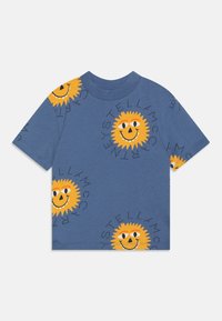 Camiseta de manga corta azul con caras de sol sonrientes amarillas repetidas y texto circular negro alrededor de cada sol.