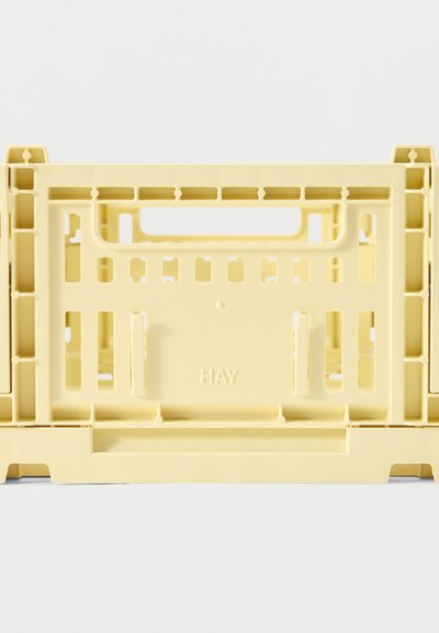 Caisses de rangement en plastique jaune pâle empilées, avec des découpes rectangulaires et le nom de la marque "HAY" embossé sur le côté.