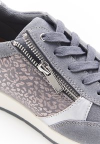 Baskets en suède gris avec un panneau en imprimé léopard, une fermeture éclair argentée, des lacets plats et un accent en cuir blanc sur le côté.