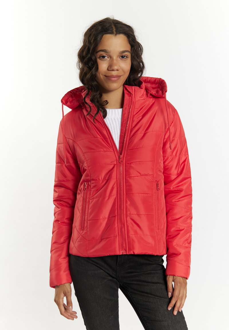 Giacca rossa di tipo puffer con zip frontale, cappuccio e due tasche laterali. Presenta un motivo trapuntato e una texture liscia. Abbinata a pantaloni neri.