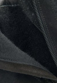 Wnętrze czarnych skórzanych botków, z gładką skórą i miękkim zamszem oraz detalami zamka, podkreślającymi kontrast tekstur i akcenty szwów.