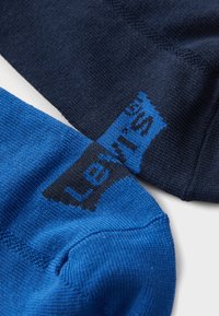 Két pár zokni: az egyik sötétkék, a másik élénk kék, mindkettő sima textúrájú, és a kék zoknin fekete 'Levi’s' logó található.