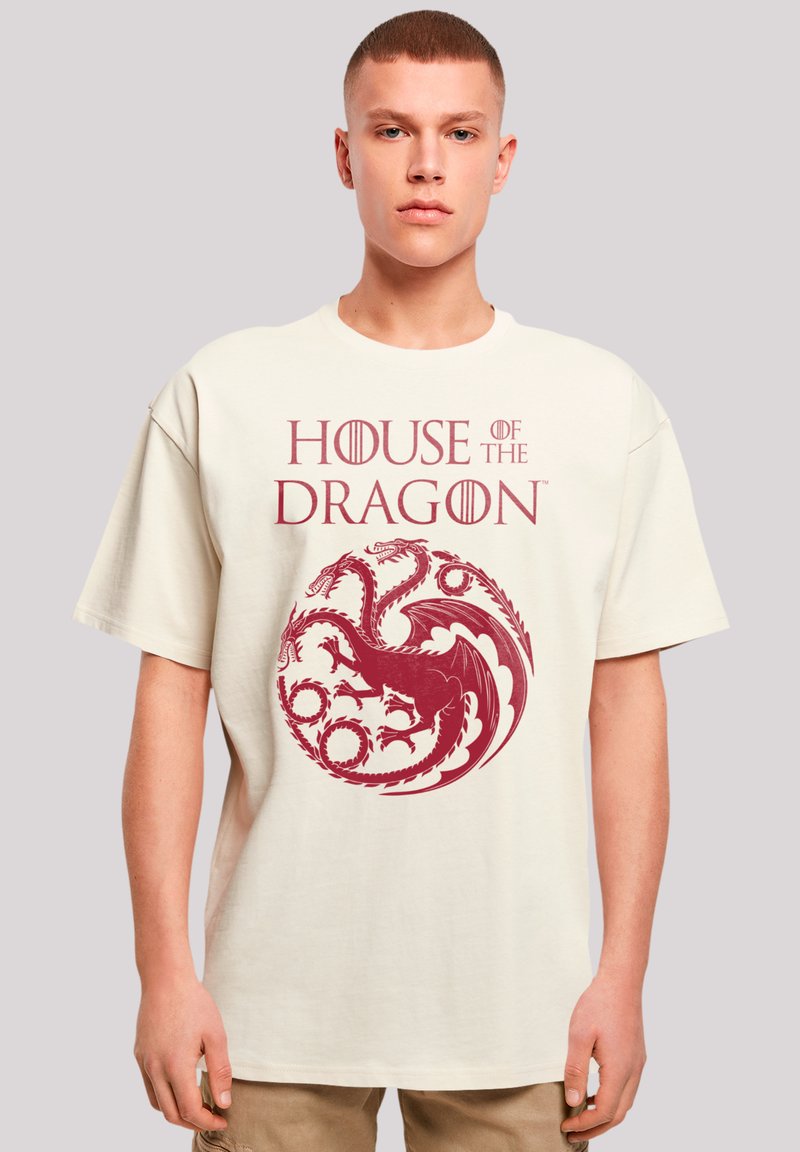 Beige cotton t-shirt featuring a large red graphic of a dragon and text "HOUSE OF THE DRAGON," short sleeves, and a relaxed fit.
