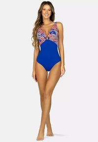 Jednoczęściowy strój kąpielowy w intensywnym niebieskim kolorze, z wzorzystym materiałem przy dekolcie i okrągłym akcentem oraz szerokimi ramiączkami.