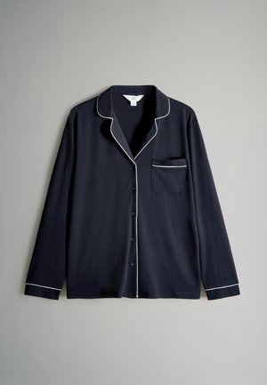 Maglietta da pigiama a maniche lunghe blu navy realizzata in tessuto morbido, con piping bianco sul colletto, sulla tasca e sui polsini, con chiusura frontale a bottoni.