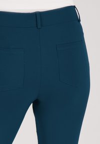 Teal stretchbroek met een soepele textuur, met een slim fit, twee achterzakken en een middelhoge waistband.