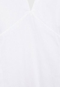 Vitt tyg med en slät textur, med en geometrisk design i mitten. Formen är smidig och åtsittande, med minimal detaljering.