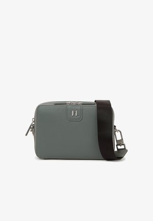 Sac bandoulière rectangulaire en cuir gris avec logo argenté, fermeture éclair et large sangle noire réglable sur fond blanc.