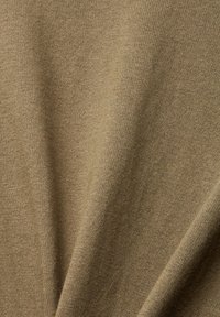 Tissu tricoté vert olive, texturé avec une surface douce. Le matériau présente un léger éclat et des plis, indiquant sa flexibilité et sa fluidité.