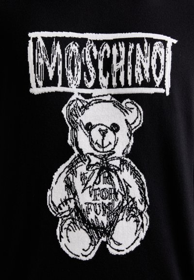 Tela negra con un gráfico blanco de un oso de peluche con un lazo, etiquetado "Moschino" arriba, en un diseño juguetón y a modo de boceto.