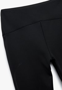 Leggings sportivi neri con vita alta, finitura opaca liscia, cuciture piatte e un sottile dettaglio laterale per un tocco di stile in più.