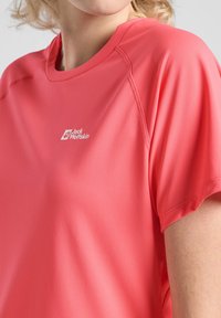 Korte mouwen sportshirt van felroze stof met een gladde textuur. Bevat het "Jack Wolfskin"-logo in het wit op de borst.