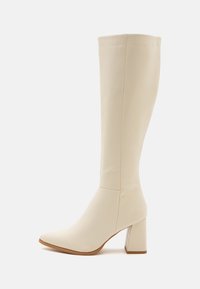 Botte blanche montant jusqu'aux genoux avec un bout pointu et un talon bloc, fabriquée en matériau lisse. Présente un design élégant avec des coutures minimales.