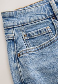 Lyseblå denimjeans med høj talje, fem-lomme-design, synlige syninger og en lille møntlomme med nitter.