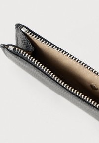 Carteira preta de couro com superfície texturizada, apresentando um zíper prateado e forro interior bege. Aberta, mostrando dois compartimentos.