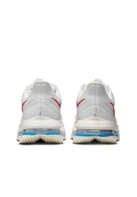Des chaussures de sport blanches avec des accents rouges, tige en mesh, col rembourré et unité de coussin d'air visible en bleu. Semelle extérieure en caoutchouc avec un motif de traction.