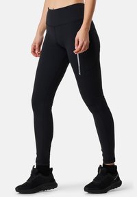 Black athletic leggings with a high waistband, featuring side pockets and a reflective stripe detail. Made from stretchable fabric.