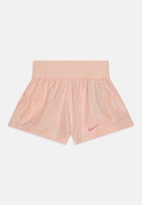 Persikinės spalvos sportinės šortai, pagaminti iš lengvos medžiagos, su elastine juostele ir šoninėmis kišenėmis, priekyje puikuojasi rožinė Nike emblema.