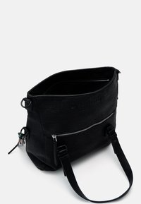 Czarna skórzana torba typu tote z teksturowanym wykończeniem, wyposażona w kieszeń na zamek, dwa regulowane paski oraz otwarcie od góry.