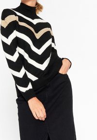 Suéter a rayas en blanco y negro con un cuello alto que presenta patrones de espiga. Acabado con una franja metálica dorada. Textura suave.