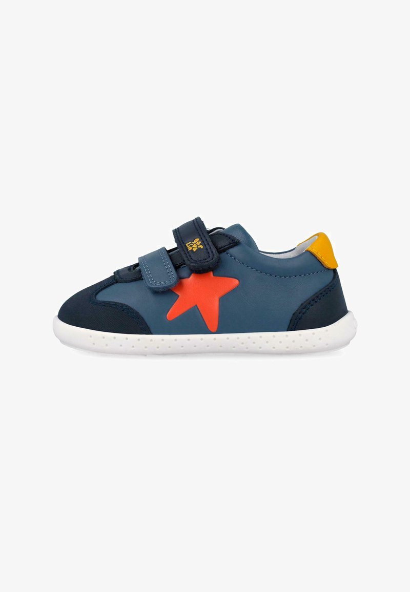 Zapatilla deportiva azul marino para niños con suela blanca, estrella naranja en el lateral, lengüeta amarilla en el talón y dos tiras de velcro.
